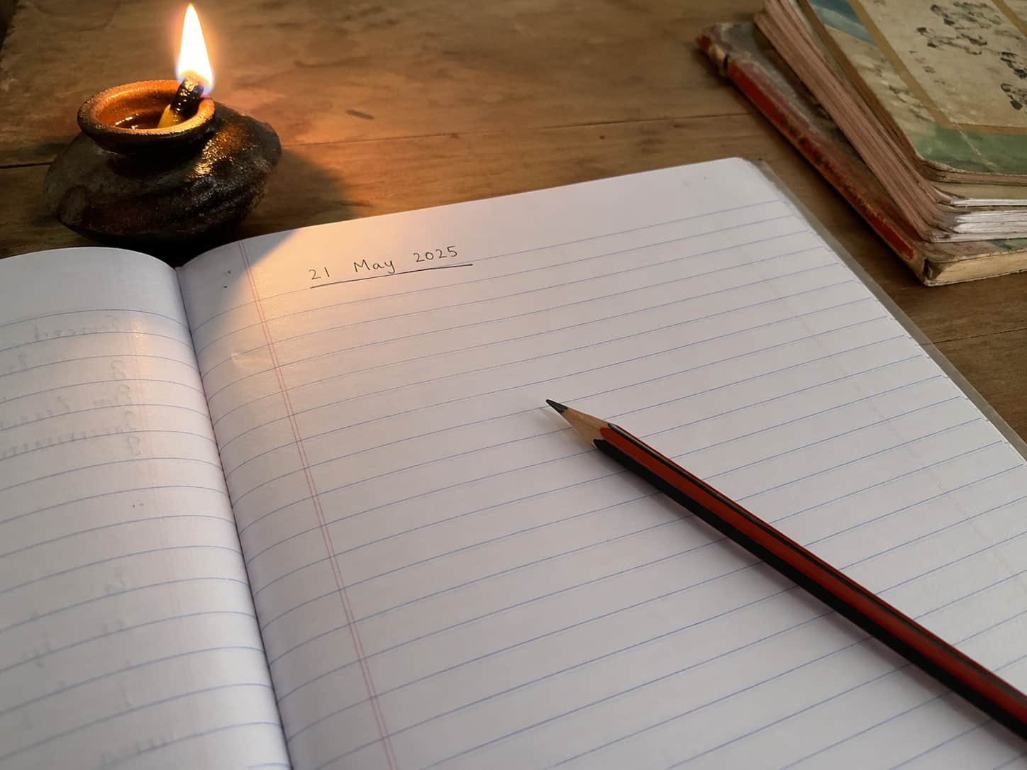 A student working on homework at home by candlelight