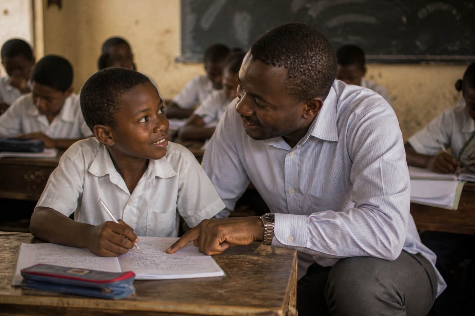 A teacher giving individual encouragement to a student looking at their work
